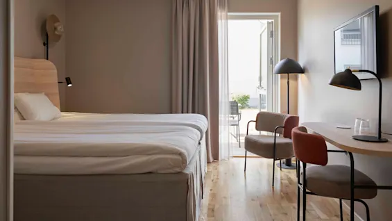 Inbjudande hotellrum med bekväma sängar, ett funktionellt skrivbord och tillgång till en uppfriskande uteplats.
