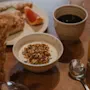 A delicious breakfast spread on a wooden table featuring yogurt with granola, coffee, juice, and a pastry with grapefruit.