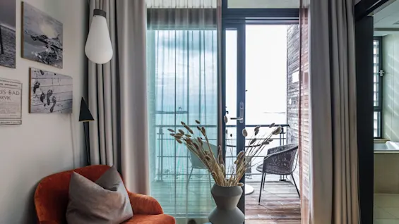 A cozy room at Farris Bad in Larvik with a balcony overlooking the sea. FARRIS BAD LARVIK text on wall art.