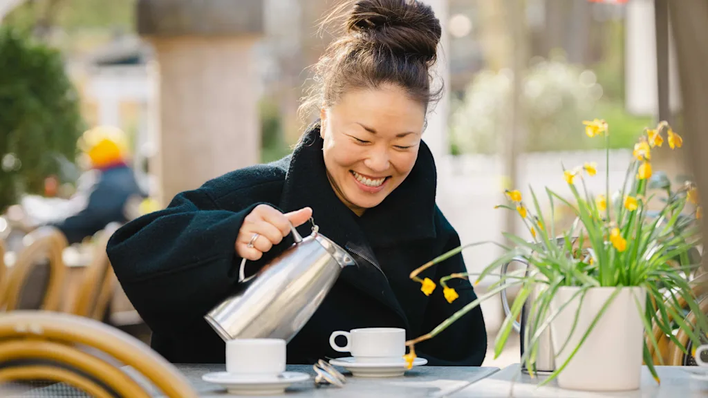 Woman drinking coffee at café in Copenhagen.