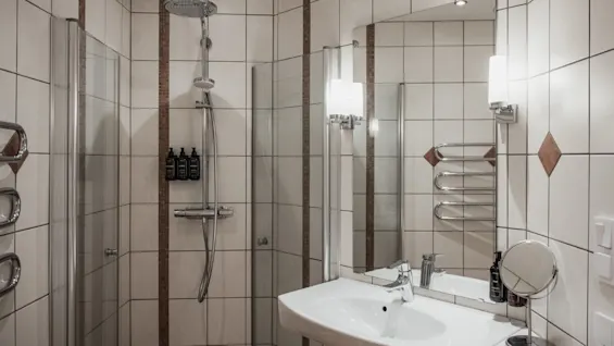 Et moderne bad med flislagt dusj og vask på Home Hotel Norre Park i Halmstad.
