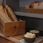 En rustikk utstilling av ferskt brød inkludert baguetter og knekkebrød, med skåler med smør og kremost.