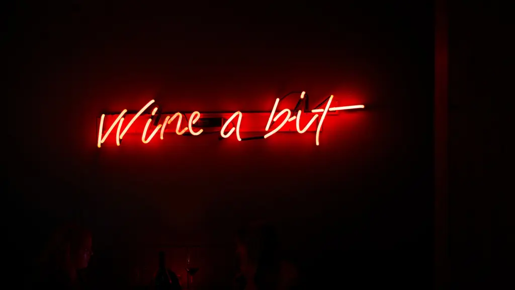 Et skilt i rødt lys med teksten "Wine a bit"
