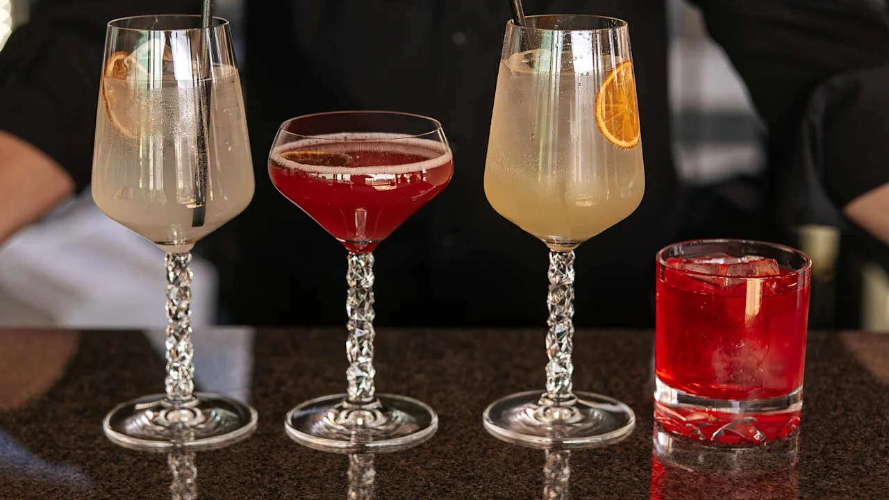 Clarion Hotel Signin baarimikko esittelee neljä värikästä cocktailia baaritiskin ääressä, valmiina tarjoiluun.