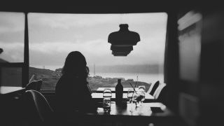 Woman looking out of window at restaurant, photo competition 2021_16_9