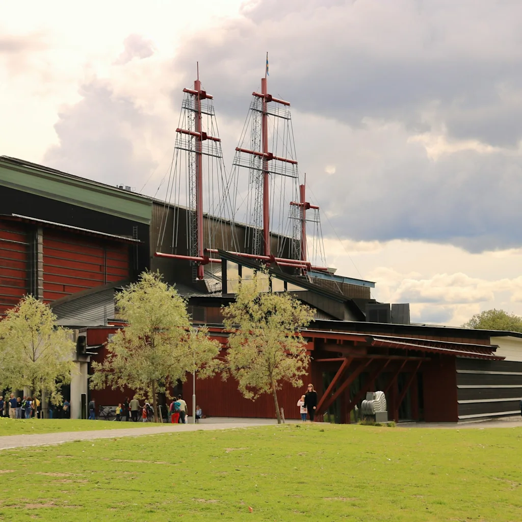 Vasamuseet Stockholm ulkoa päin ja sen katosta kohoavat ikoniset laivan mastot pilvisenä päivänä.
