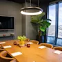 Et moderne og innbydende møterom med et stort trebord, komfortable stoler, en TV-skjerm og en lys vindusutsikt.