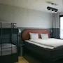 Ett modernt hotellrum på Stopover Hotel Falkenberg med en bekväm dubbelsäng och en våningssäng, perfekt för familjer.