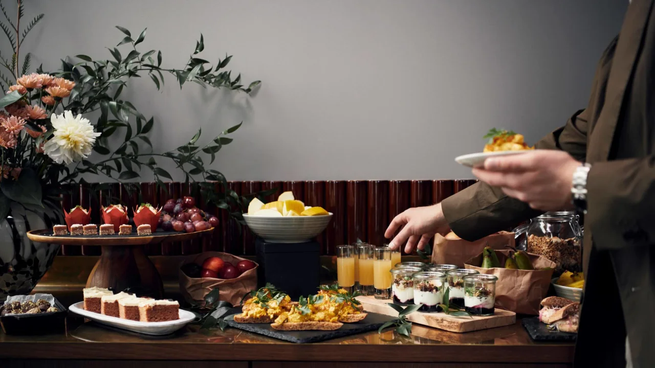 Person serving themselves at a buffet of assorted foods, with focus on action and elegant presentation.