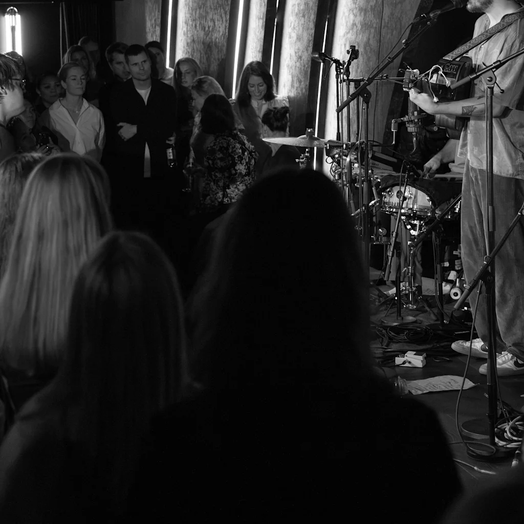 Ett liveband som uppträder på scen inför en engagerad publik under en intim konsert.