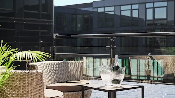 A relaxing outdoor seating area at Farris bad in Larvik, with champagne on ice, ready for a delightful moment.