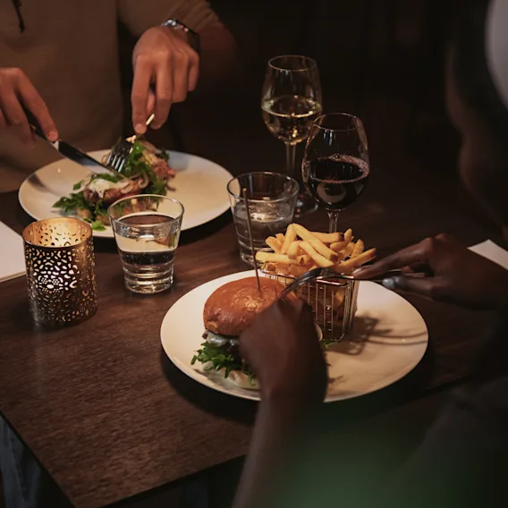 Två personer som njuter av en mysig middag tillsammans vid ett levande ljus på en restaurang