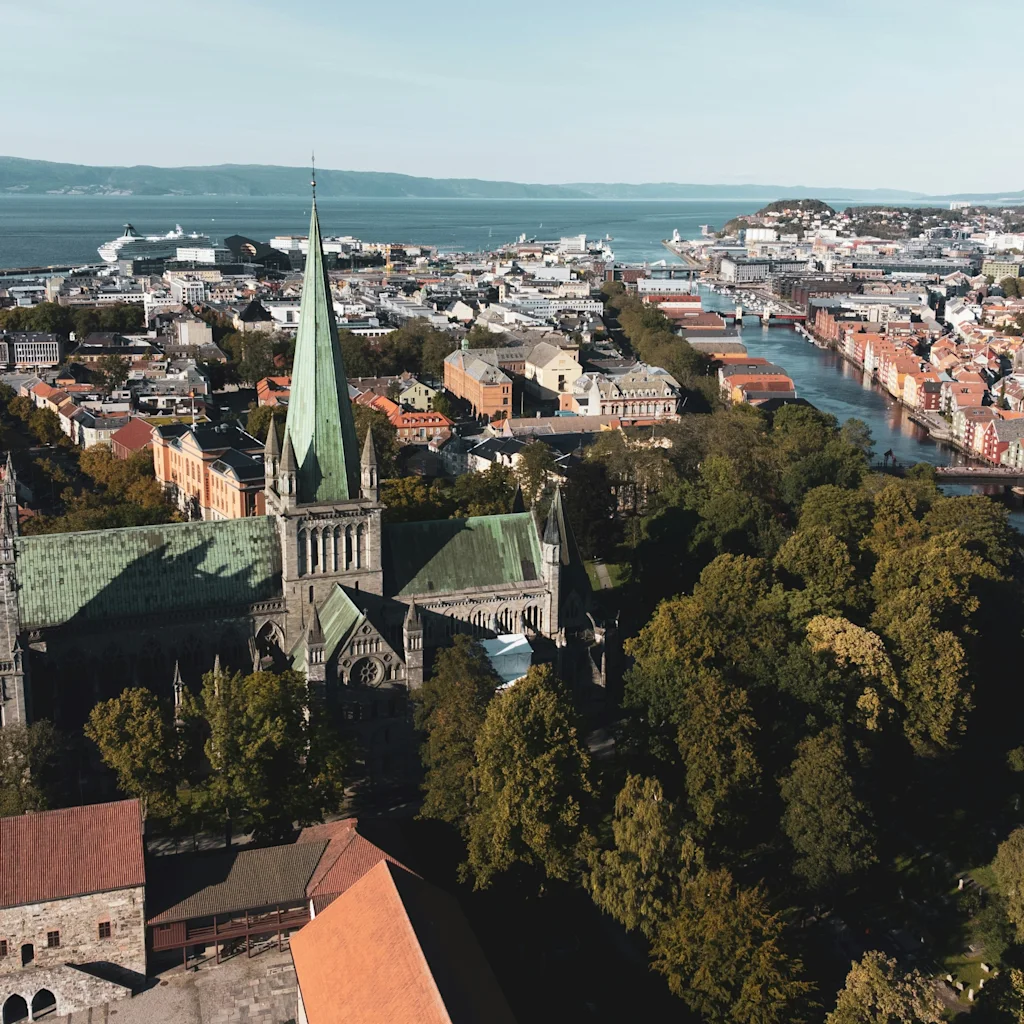 Ilmakuva historiallisesta kaupungista, jossa on suuri katedraali, mutkitteleva joki ja monia rakennuksia, kaikki suuren vesistön ja etäisten kukkuloiden taustalla.