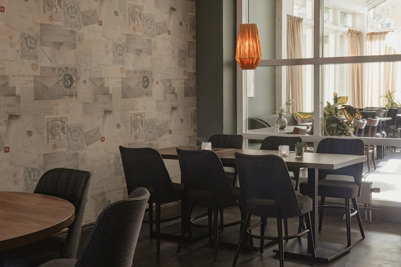 Home Hotel Post matplats med unik tapet med gamla brev och frimärken, vilket skapar en nostalgisk atmosfär.