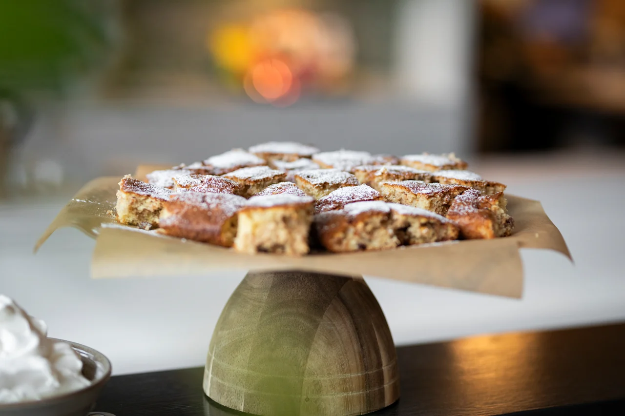 Houkutteleva esillepano vastaleivottuja kakkupaloja, kevyesti tomusokerilla pölytettynä, valmiina nautittavaksi.