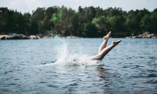 Dyk ner i en svensk sjö på sommaren