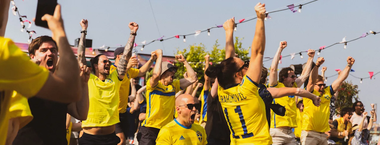 Engasjert folkemengde heier på et fotballarrangement, armene hevet i feiring. Fotbolls-VM 2026 Stockholm Under Stjärnorna SUS.