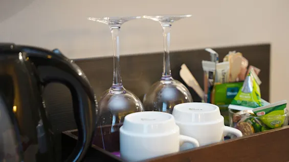 Hotellihuoneen virvokepiste, jossa on vedenkeitin, lasit, mukit ja juomatarvikkeet, käyttövalmiina Quality Hotel Sundsvallissa.