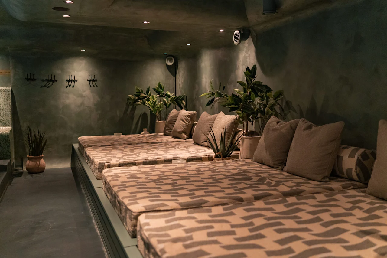 Rauhallinen lounge-alue mukavilla päivävuoteilla, rehevillä vihreillä kasveilla ja pehmeällä valaistuksella, täydellinen rentoutumiseen.