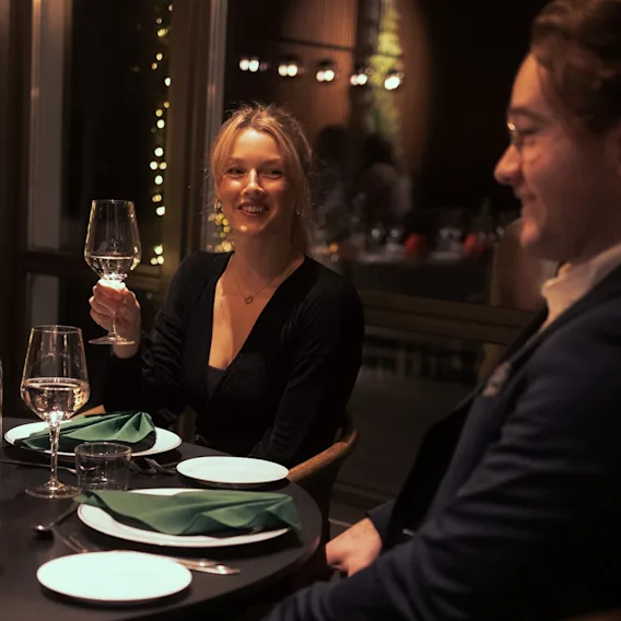 Et par som nyter en hyggelig middag på en stemningsfull restaurant.