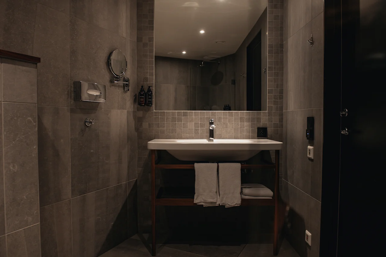 A well-appointed bathroom with a sink, mirror, and fresh towels, providing a comfortable space for personal care.