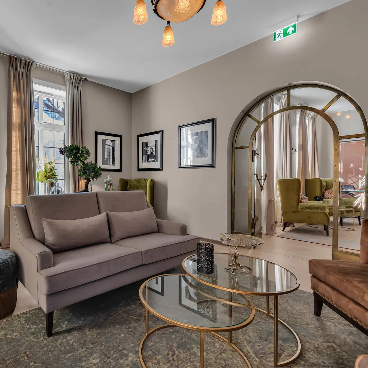 Elegant vardagsrum med soffa, fåtöljer och inramade bilder, visar en bekväm, modern interiör.
