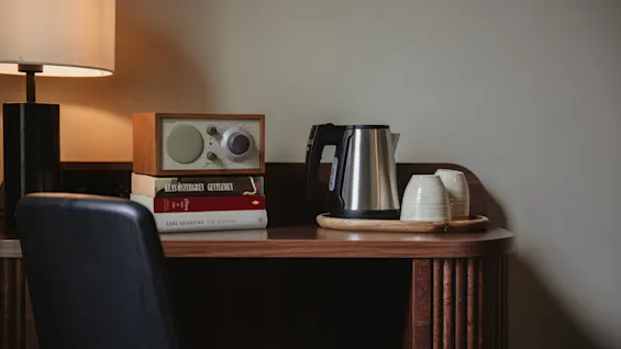 Home Hotel Tapetfabriken. Desk with lamp, radio, KLAS OSTERGREN GENTLEMEN, SALO, ASNE SEIERSTAD TVA SYSTRAR, kettle, cups.