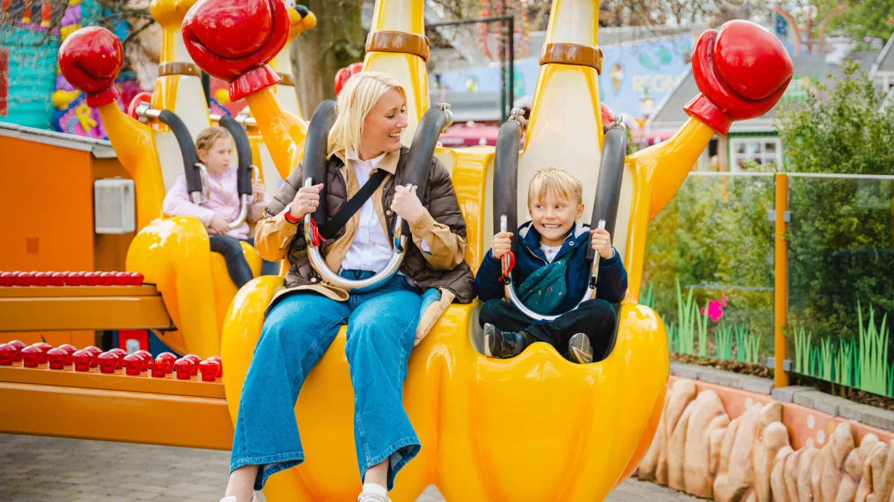 Mother and son riding a carousel at amusement park Bakken, in Copenhagen. 