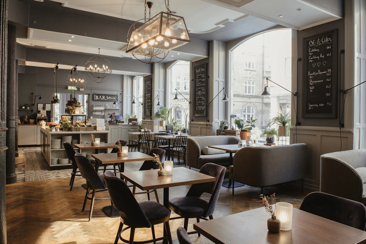 En innbydende restaurant eller bar med varierte sitteplasser. Tavlemenyer viser 'Ol & Cider' og 'Roll Inn' utvalg.
