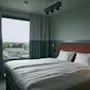 Ett bekvämt hotellrum på Stopover Hotel Falkenberg med två enkelsängar och fönsterutsikt över det omgivande landskapet.