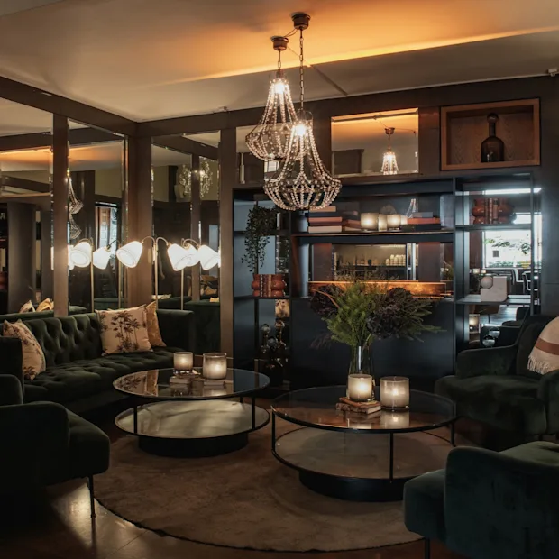 En lyxig och inbjudande hotellounge på Home Hotel Grand, Helsingborg, med plyschmöbler och varm belysning.