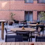 Outdoor patio at Comfort Hotel Vesterbro with wooden tables and chairs, ready for guests to relax or dine.