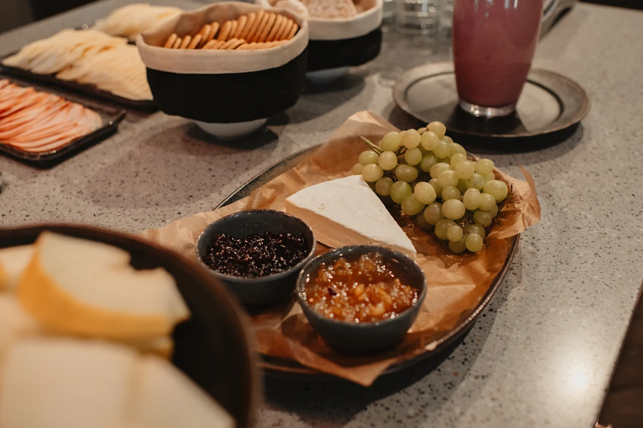 Et deilig utvalg av ost, druer, syltetøy og kjeks, perfekt for en herlig frokost eller mellommåltid.