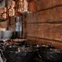 Et varmt og indbydende buffetområde med mad serveret i sorte skåle, oplyst af kobberlamper, sat mod en trævæg.