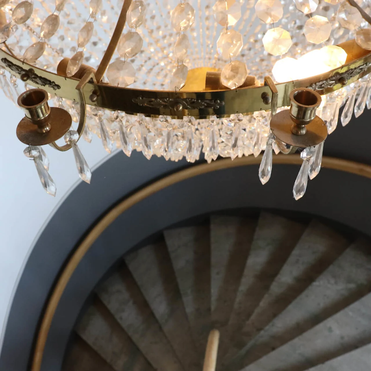 En krystallkrone henger over en spiraltrapp.