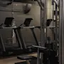 Et moderne fitnesscenter med flere løbebånd og vægtmaskiner, klar til en træning.