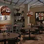 Et varmt og innbydende restaurant- eller kaféinteriør med bord, stoler, en lang benk, kobberpendellamper og innrammet kunst.