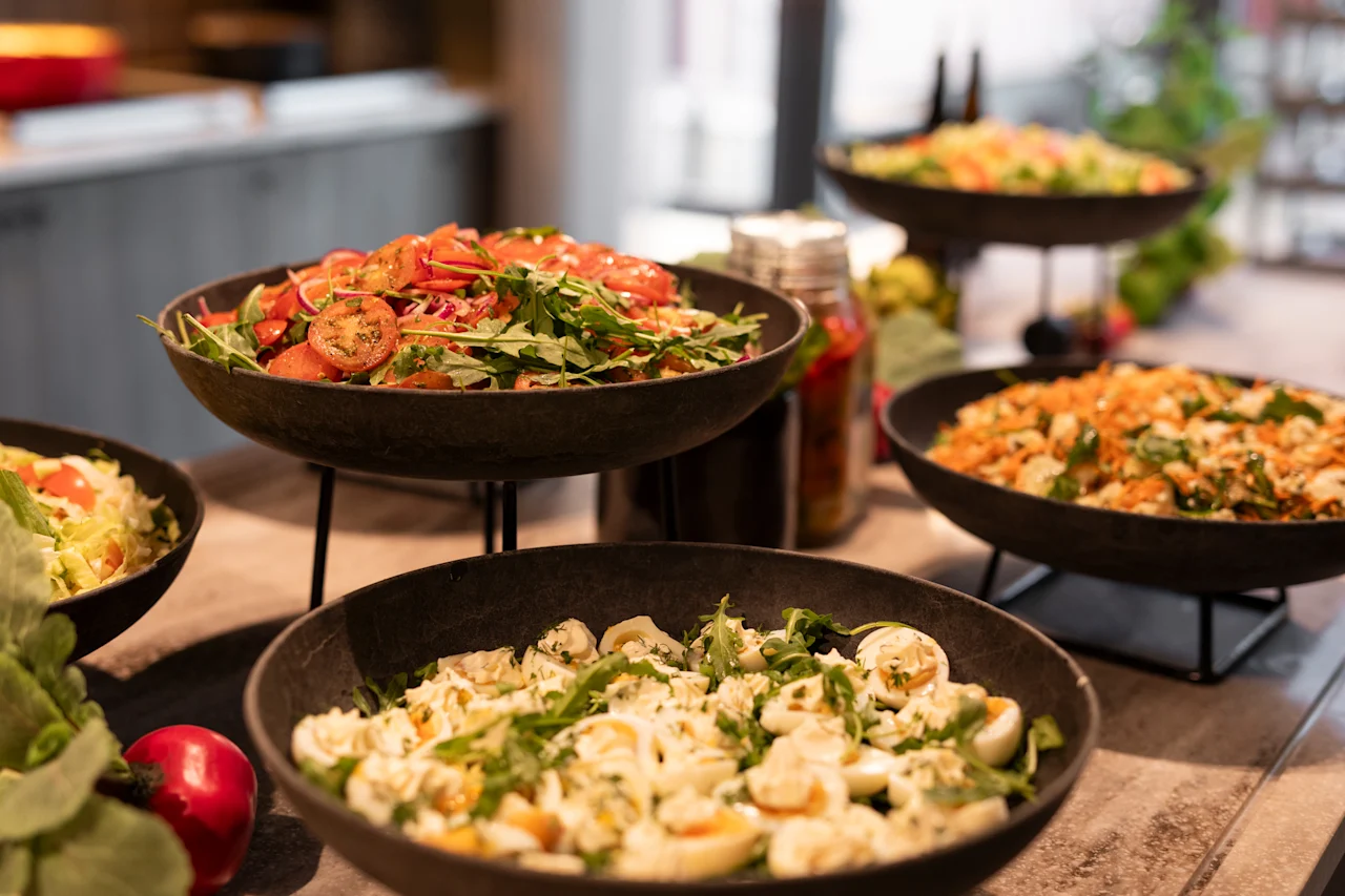 Kutsuva buffet, jossa on erilaisia ​​tuoreita salaatteja, valmiina vieraille nauttimaan terveellisestä ateriasta.