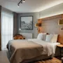 Et koselig hotellrom med en stor seng, sengegavl i tre og varm belysning, som inviterer til et komfortabelt opphold.