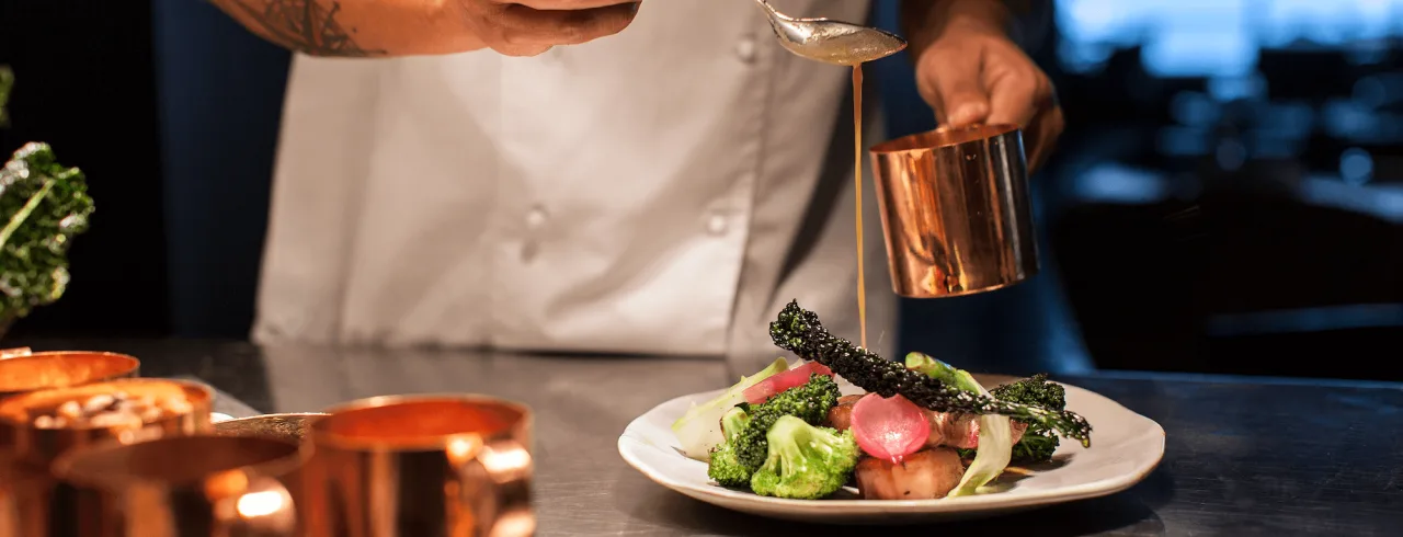 Chef preparing food in the kitchen at Vox Restaurant in Jönköping.