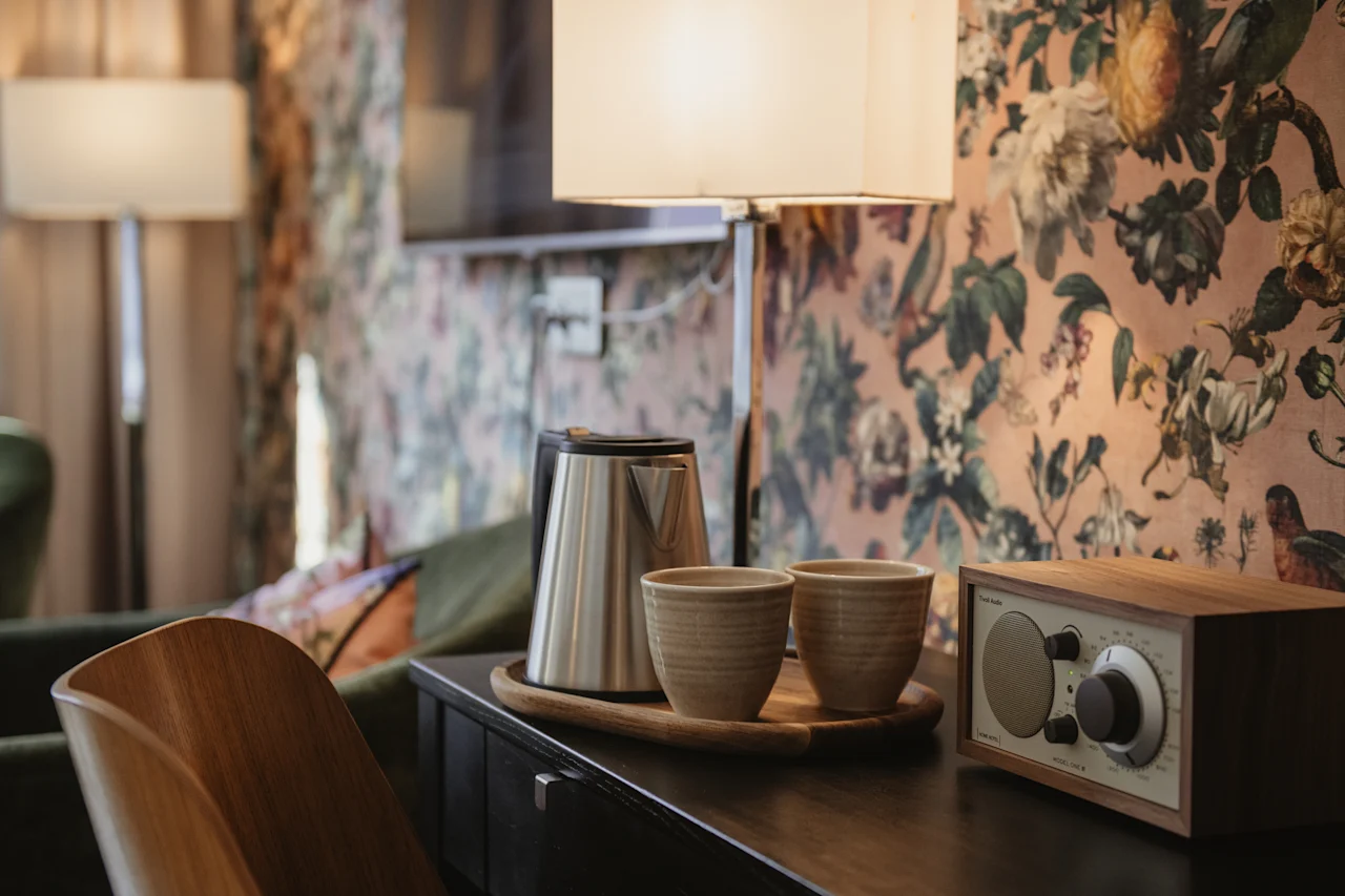 Et indbydende hotelværelse på Home Hotel Norre Park, med en te- og kaffestation og en radio på en mørk træoverflade.