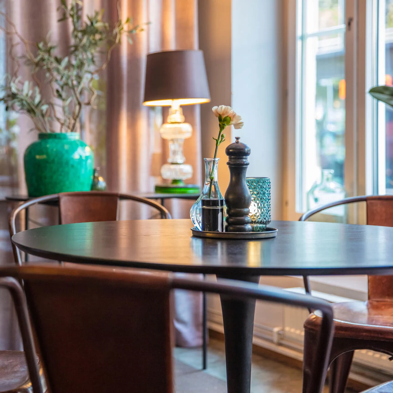 A cozy café scene with wood furnishings, flower, and warm lighting.