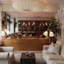 A warm and inviting hotel lounge with comfortable sofas, a fireplace, bookshelves, and decorative lighting.