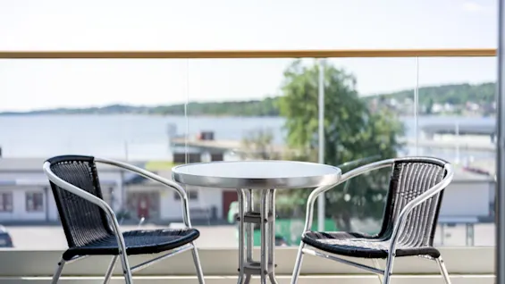 Quality Hotel Grand Larvik: En solig balkong med ett bord och två stolar, som erbjuder en avkopplande utsikt över vattnet.