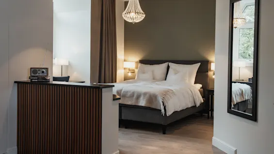 Et stilfullt og komfortabelt hotellrom på Home Hotel Norre Park i Halmstad, med en koselig seng og et lite arbeidsområde.