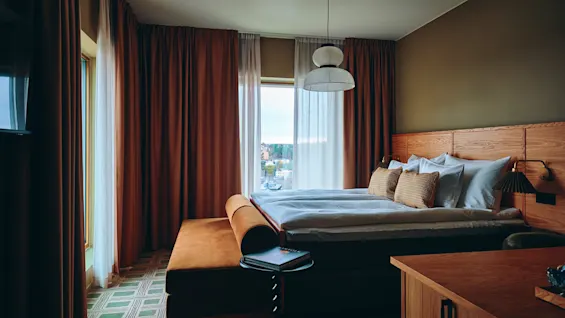 Et komfortabelt hotellrom med seng og sittegruppe, klart for gjester.