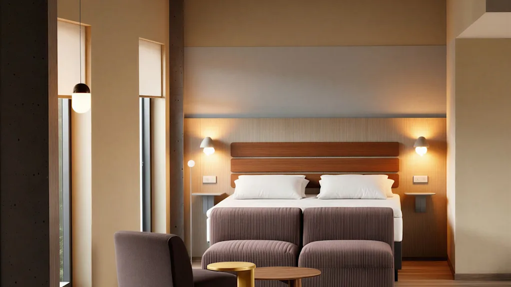 Et moderne og indbydende hotelværelse med en komfortabel seng, et hyggeligt siddeområde og varm belysning.