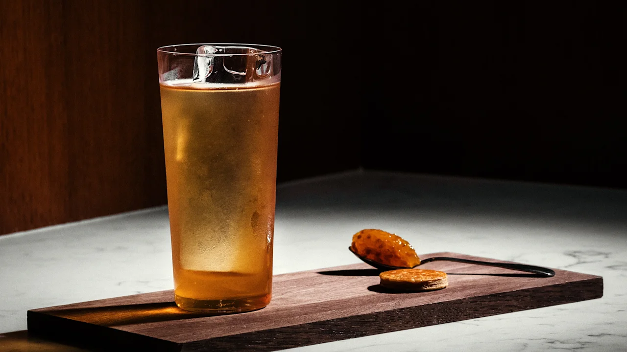 A refreshing drink and small bites served on a wooden board at Hotel Kämp – Kämp Bar.