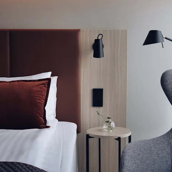 Ett mysigt och modernt hotellrum på Quality Hotel Arlanda XPO, med en bekväm säng, sängbord och läsfåtölj.