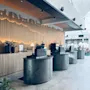 En moderne hotellobby med flere selvbetjente innsjekkingsstasjoner. En dekorativ trevegg med bakgrunnsbelysning gir varme. SELF CHECK-OUT.